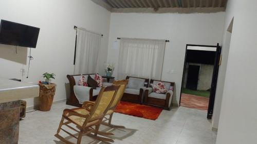 uma sala de estar com um sofá e cadeiras e uma televisão em Shammah-casa de descanso em Valledupar