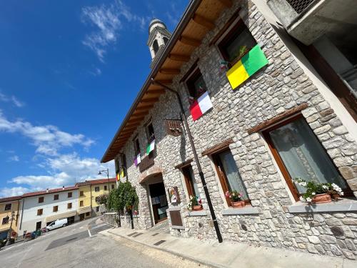 a building with colorful flags on the side of it at Locanda B&B Da Nati in Arba