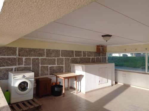 cocina con lavadora y mesa en CRALS - Casa do Corgo, en Barroselas