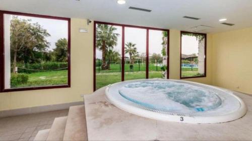 een groot bad in een kamer met ramen bij Luxury 3 beds Villa inside the Resort and Country Club in Estepona