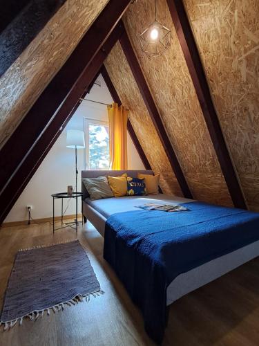 Un dormitorio con una cama grande en un ático. en Ostoja Lipiny, en Sompolno