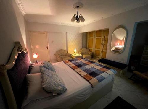 een slaapkamer met een groot bed en een geruite deken bij Room for transit near airport in Caïro