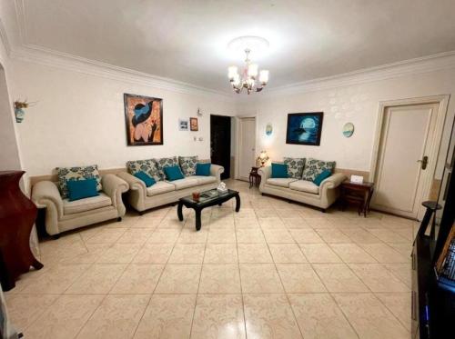 een grote woonkamer met banken en een tafel bij Room for transit near airport in Caïro