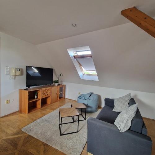 a living room with a blue couch and a tv at Bydlím U Arény in Nová Ves