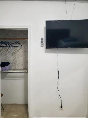 a flat screen tv hanging on a white wall at B3 Best Value on Private Bedroom with Private Bathroom in Little Havana, Miami in Miami