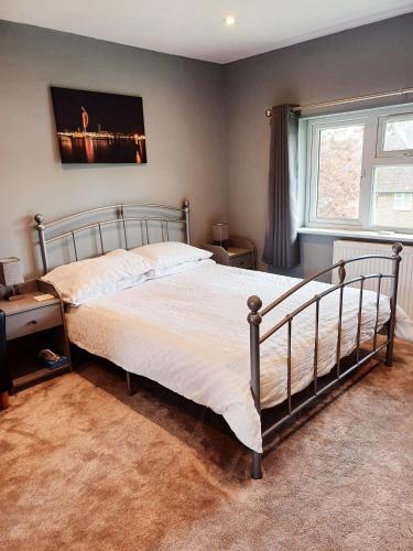 een slaapkamer met een groot bed en een raam bij Large double room with spacious ensuite in Southbourne