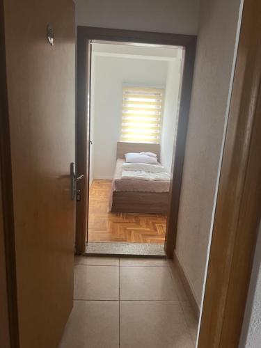 a door leading to a bedroom with a bed in a room at SARAH APARTMENTS in Gusinje