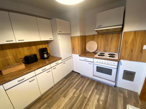 a kitchen with white cabinets and a white stove at Ferienhaus Sutje in Loose