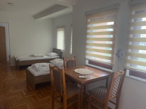 a dining room with a table and chairs and a bedroom at SARAH APARTMENTS in Gusinje