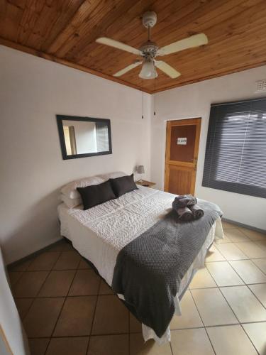 1 dormitorio con 1 cama y ventilador de techo en Le Petit en Vredendal