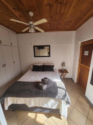um quarto com uma cama e uma ventoinha de tecto em Le Petit em Vredendal
