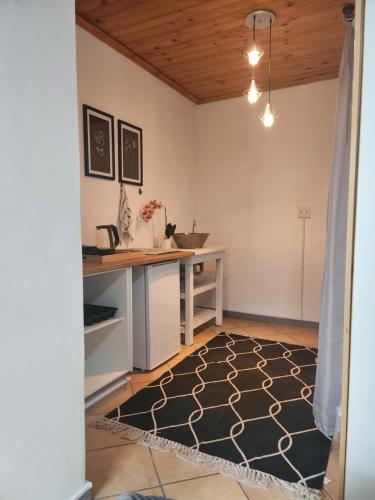 uma cozinha com um balcão, uma mesa e um tapete em Le Petit em Vredendal