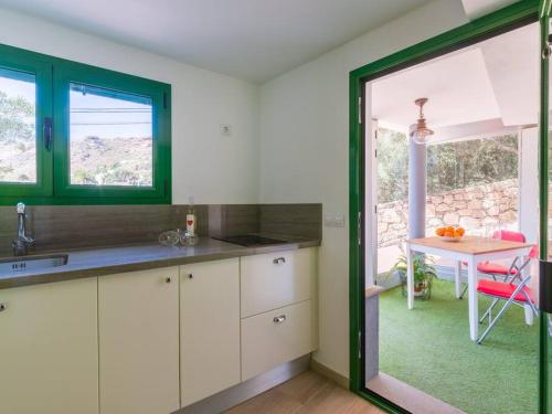 een keuken met witte kasten en een tafel en een raam bij Casa Perilla in Temisas