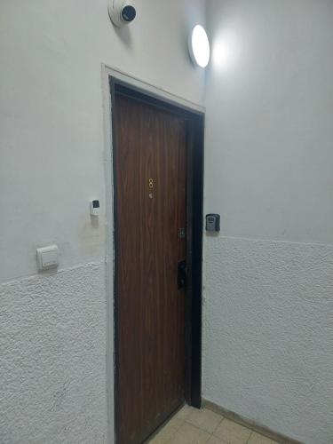 a brown door in a white room with a light at Aparthotel Banana Beach in Tel Aviv