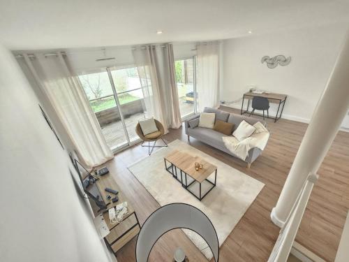 vistas panorámicas a una sala de estar con sofá y mesa en Maison proche toutes commodités en Le Bouscat