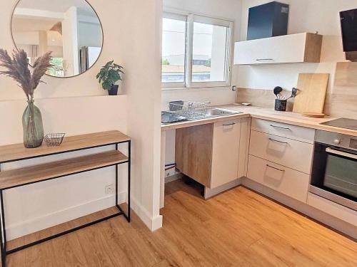 uma cozinha com armários brancos, um lavatório e um espelho em Maison proche toutes commodités em Le Bouscat