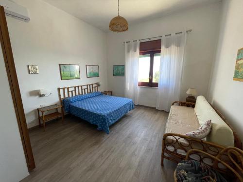 a bedroom with a bed and a couch and a window at Appartamenti in Villa Calamoni in Favignana