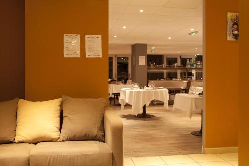 a living room with a couch in a restaurant at Villa Mariale by Popinns in Lourdes
