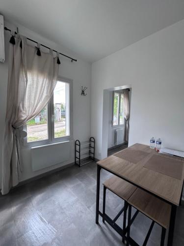 a dining room with a table and a window at La petite maison in Brienon-sur-Armançon