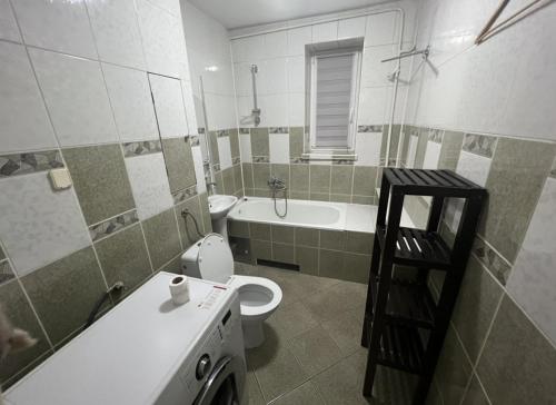 a bathroom with a toilet and a sink and a washing machine at Warsaw Lux Rooms in Warsaw