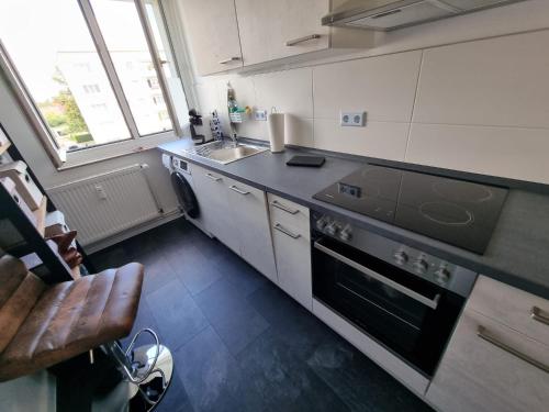 uma pequena cozinha com um fogão e um lavatório em Beste Apartments em Meerane