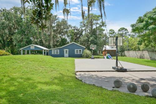a woman is playing basketball on a basketball hoop at Cozy River Cabin Family Friendly Dock Playset Bball Court in Clay Landing