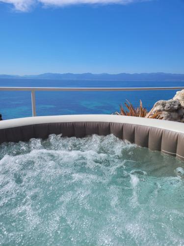 a jacuzzi tub with the ocean in the background at Villa Rosa in SantʼElia