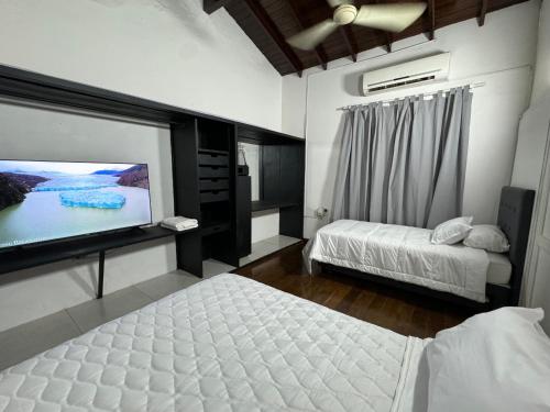 a bedroom with two beds and a flat screen tv at Altillo a minutos del centro de Asunción in Asuncion
