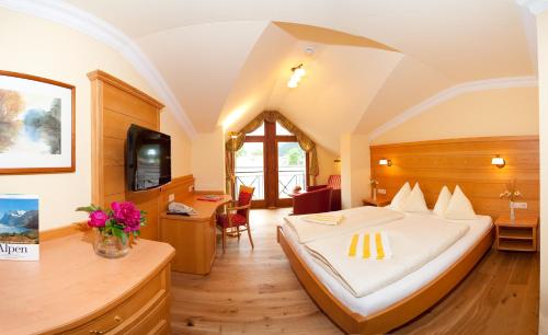 a hotel room with a bed and a desk at Hotel Guggenberger in Kleinarl