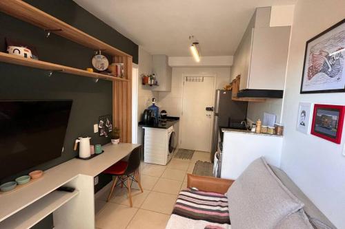 a kitchen with a desk and a kitchen with a refrigerator at Estúdio a 500m Metro Joao Dias in Sao Paulo
