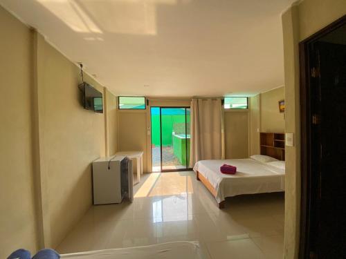 1 dormitorio con 1 cama y TV. en Cabinas Travel, en Fortuna