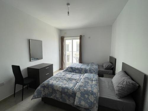 ein Schlafzimmer mit einem Bett, einem Sofa und einem TV in der Unterkunft R3 RN Retreat in St Paul's Bay