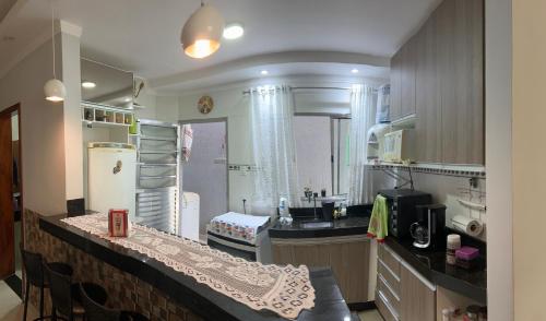 uma cozinha com um balcão, uma pia e uma geladeira em CASA FAMILIAR “SANTA PAZ” 2 em Aparecida