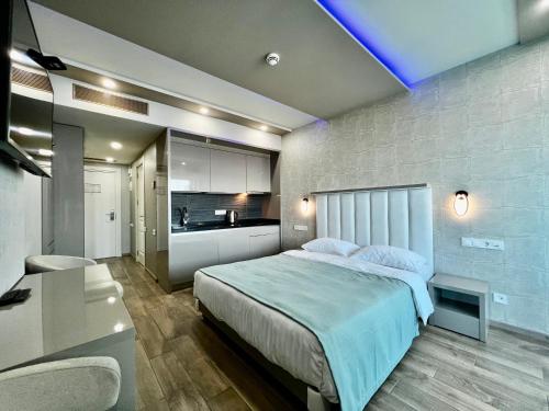 a bedroom with a large bed and a kitchen at My Sunshine Apartments in Batumi in Batumi
