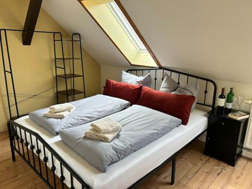ein großes Bett mit roten und weißen Kissen darauf in der Unterkunft Ferienwohnung Sprejnik - Residenz Sonnenhübel in Großschönau