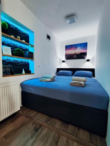 a bedroom with a large bed with blue sheets at Studio Apartment FortyOne in Orebić