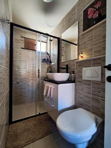 a bathroom with a toilet and a sink and a shower at Studio Apartment FortyOne in Orebić