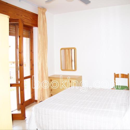 a white bedroom with a bed and a mirror at InternoUno in Diamante