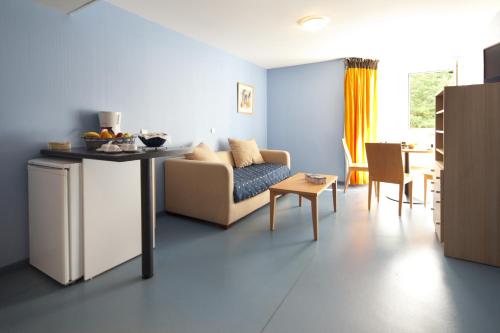 a living room with a couch and a table at Villa Mariale by Popinns in Lourdes