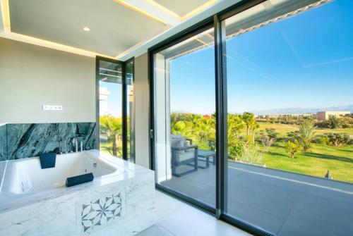 a bathroom with a tub and a large window at Villa Simeon Marrakech in Marrakech