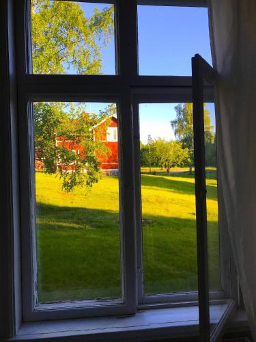 een open raam met uitzicht op een tuin bij Big spacious countryhouse typical Swedish red wooden house (1h from Stockholm) in Malmköping
