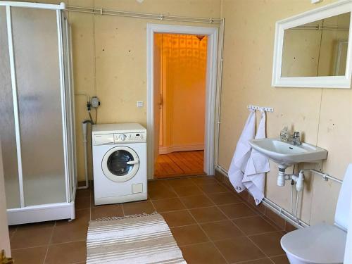 uma casa de banho com uma máquina de lavar roupa e um lavatório em Big spacious countryhouse typical Swedish red wooden house (1h from Stockholm) em Malmköping