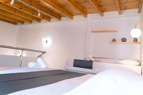 a bedroom with two beds and a wooden ceiling at Vila Anxhelo in Vlorë