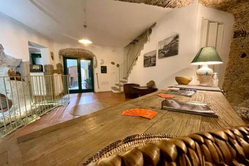 een woonkamer met een houten tafel en een bank bij Sardinian Gallery Fonte in Bosa