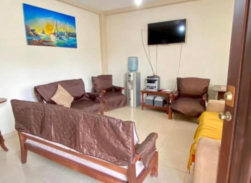 uma sala de estar com sofás e uma televisão de ecrã plano em Jurado, Casa Hospedaje em Tonsupa
