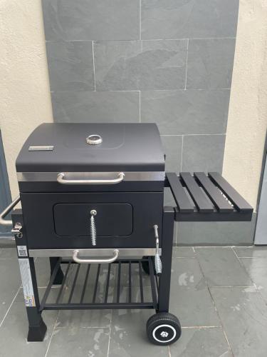 a charcoal grill on a cart next to a bench at BULEVAR SUITE in Nava de la Asunción