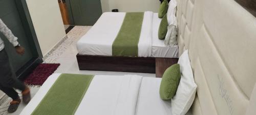 two twin beds in a room with at Hotel Olive Smart Stay in Agra