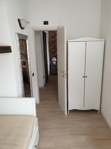 a bedroom with a white cabinet and a mirror at Casa Giacomina in Perledo