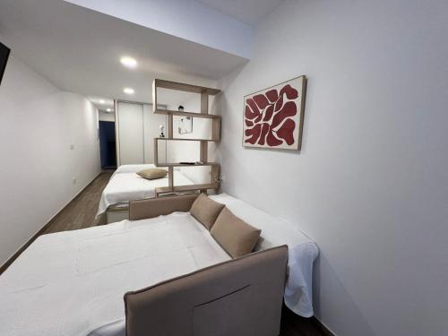 ein kleines Zimmer mit 2 Betten und einem Sofa in der Unterkunft White House in Castellón de la Plana