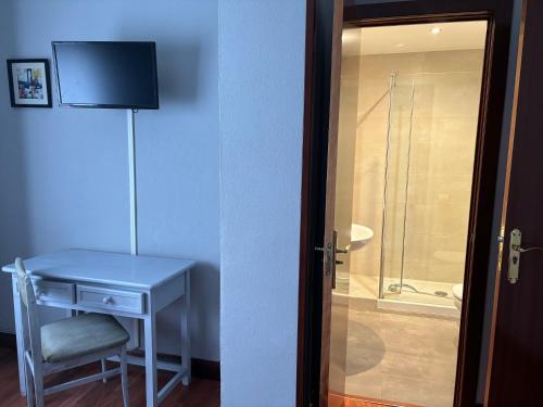 uma casa de banho com uma mesa e uma cabina de duche em vidro. em Bakiola em Arrankudiaga